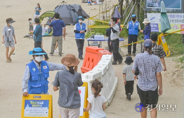 6일 오후 안산시 대부도 방아머리해수욕장에서 안산시 해양수산과 관계자들이 해수욕장 출입자들에게 출입관리를 위한 알림콜을 당부하고 있다. 윤원규기자