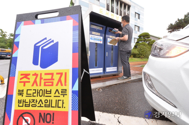 18일 오전 인천 남동구 중앙도서관 주차장 입구에서 운영을 시작한 ‘북 드라이브 스루 반납 부스’에서 한 시민이 대여 도서를 반납하고 있다. 코로나19 여파와 함께 이용 시민들의 편의를 위해 설치한 드라이브 스루 반납 부스는 연중 24시간 운영한다. 장용준기자