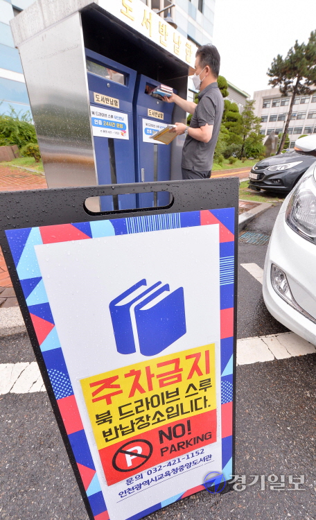 18일 오전 인천 남동구 중앙도서관 주차장 입구에서 운영을 시작한 ‘북 드라이브 스루 반납 부스’에서 한 시민이 대여 도서를 반납하고 있다. 코로나19 여파와 함께 이용 시민들의 편의를 위해 설치한 드라이브 스루 반납 부스는 연중 24시간 운영한다. 장용준기자