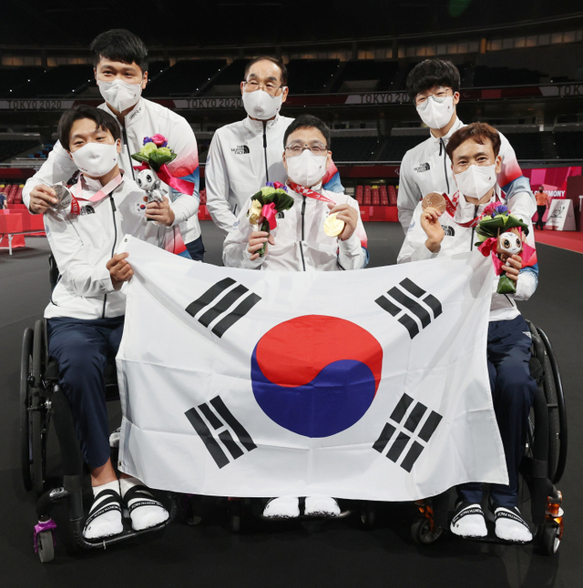 30일 오전 일본 도쿄 메트로폴리탄체육관에서 열린 2020 도쿄 패럴림픽 남자 탁구 개인전(스포츠등급 1) 시상식이 끝난 뒤 금메달을 차지한 주영대(가운데), 은메달 김현욱(왼쪽), 동메달 남기원이 함께 태극기를 들고 포즈를 취하고 있다. 연합뉴스
