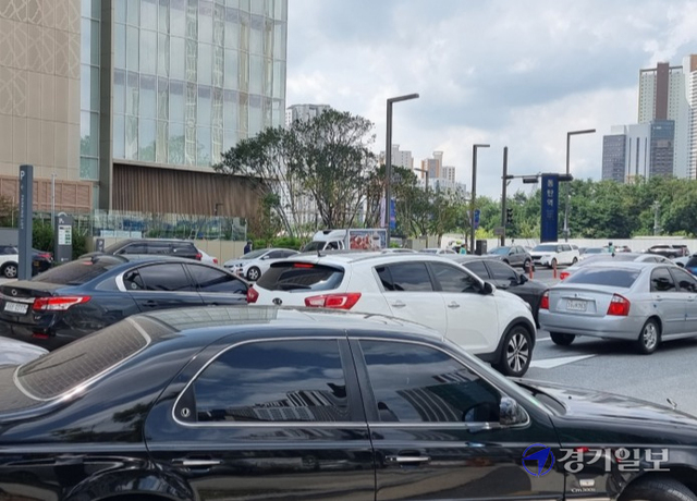 롯데백화점 동탄점이 교통영향평가 심의내용을 어기고 지하주차장 출입구 2곳을 모두 사용하면서 극심한 교통체증을 부추기고 있다. 백화점 북측 주차장 입구를 이용해 백화점으로 진입하려는 차량들로 체증을 빚고 있다. 김영호기자