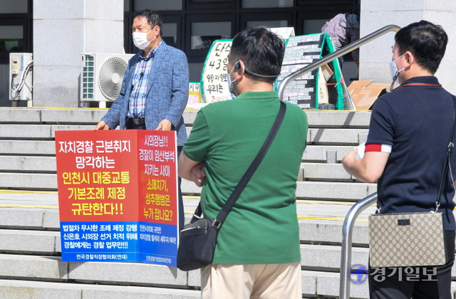 인천경찰청 직장협의회 회원들이 8일 오전 인천시청 현관 앞에서 인천시의회가 지난달 발의한 '인천시 대중교통 기본 조례안'의 철회를 촉구하는 기자회견을 하고 있다. 장용준기자