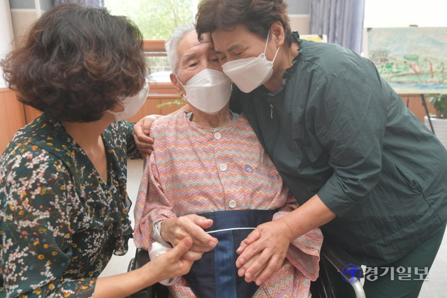 추석 연휴을 일주일 앞 둔 13일 오전 수원보훈요양원 면회실에서 아버지 이주환씨(93)를 면회 온 딸 이순복씨(70)와 이순애씨(63)가 손을 맞잡고 이야기를 나누고 있다. 정부는 이날부터 오는 26일까지 요양병원·시설에서 환자와 면회객 모두 백신 접종을 마친 경우 대면 면회를 허용한다.조주현기자