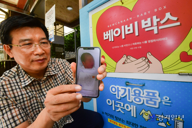 14일 오후 군포 새가나안교회 앞 베이비박스에서 이기동 목사가 과거 구조됐던 아동의 사진을 들어보이고 있다. 조주현기자