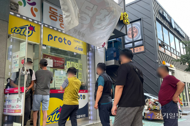 추석 연휴가 시작된 18일 오후 수원시내 한 복권방 앞에 명절을 맞아 로또복권 등을 구입하려는 시민이 줄을 서 있다. 조주현기자