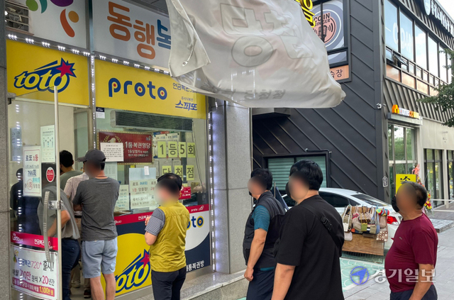 추석 연휴가 시작된 18일 오후 수원시내 한 복권방 앞에 명절을 맞아 로또복권 등을 구입하려는 시민이 줄을 서 있다. 조주현기자