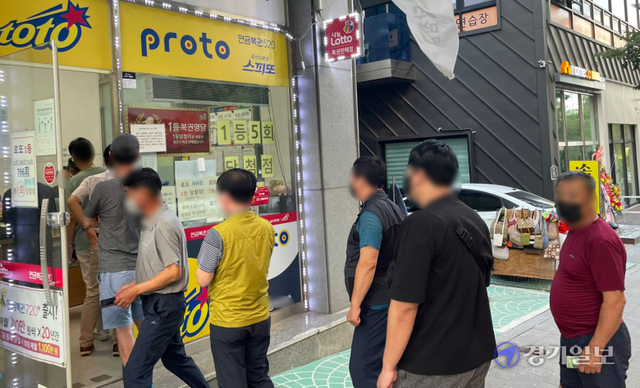 추석 연휴가 시작된 18일 오후 수원시내 한 복권방 앞에 명절을 맞아 로또복권 등을 구입하려는 시민이 줄을 서 있다. 조주현기자