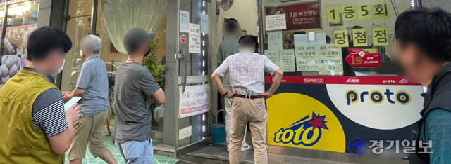 추석 연휴가 시작된 18일 오후 수원시내 한 복권방 앞에 명절을 맞아 로또복권 등을 구입하려는 시민이 줄을 서 있다. 조주현기자