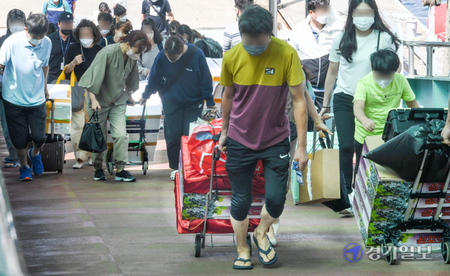 추석 연휴 마지막 날인 22일 오후 인천 옹진군 연평도에서 출발해 인천항연안여객터미널에 도착한  귀경객들이 고향의 선물을 들고 부두잔교를 빠져 나오고 있다. 장용준기자
