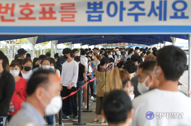 추석 연휴가 끝나자마자 전국 코로나19 신규 확진자 수가 급증하고 있다. 23일 오후 안산시 단원보건소 코로나19 선별진료소에서 검사를 받으려는 시민이 긴 줄을 이루고 있다. 조주현기자