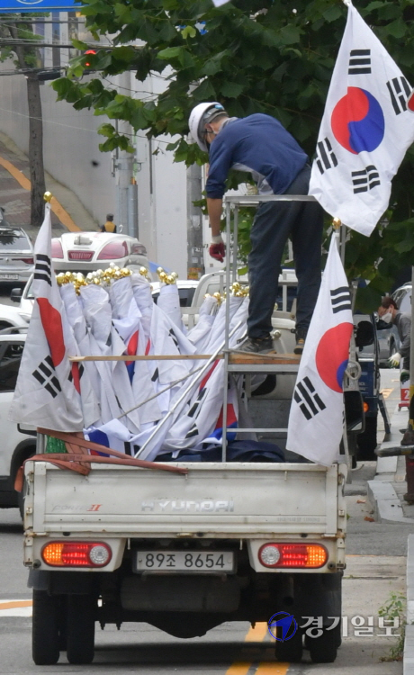 국군의 날과 개천절을 앞둔 28일 오전 수원시내 한 도로변에서 관계자가 태극기를 게양하고 있다. 조주현기자