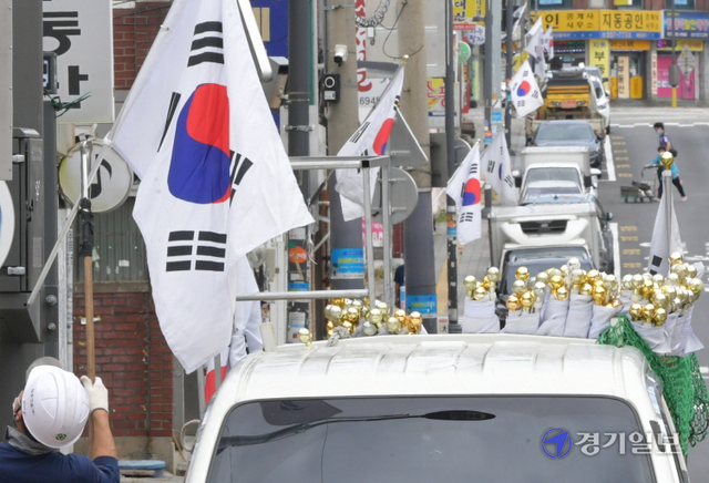 국군의 날과 개천절을 앞둔 28일 오전 수원시내 한 도로변에서 관계자가 태극기를 게양하고 있다. 조주현기자