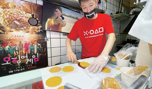 지난 12일 중국 상하이 인민광장 인근에 있는 한국식 설탕 과자 ‘달고나’ 가게에서 점원들이 설탕을 녹여 달고나 과자를 만들고 있다.  연합뉴스