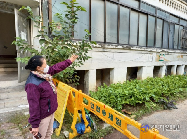 안양시 만안구 석수동 101-1번지 일원이 노후화됐으나 종교단체 반대로 재개발사업 추진이 난항을 겪고 있다. 한 주민이 기울어진 연립주택을 가리키고 있다. 노성우기자