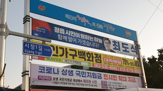 정읍시에 내걸린 정치인 현수막, 다른 상업용현수막과 함께 지정게시대에 내걸려있다.