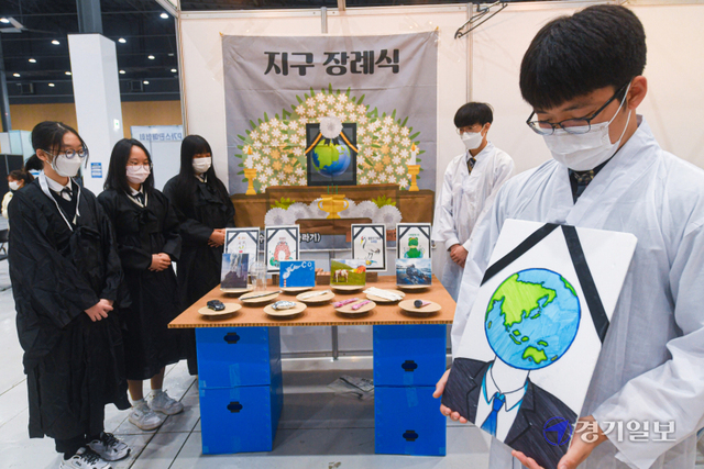 27일 오전 수원시 권선구 수원메쎄에서 열린 ‘제1회 경기도 탄소(C)공(Zero)감(Go)’행사에서 파주시 문산수억고등학교 환경동아리 학생들이 환경오염을 경고하는 메시지를 담아 지구장례식 퍼포먼스를 하고 있다. 조주현기자