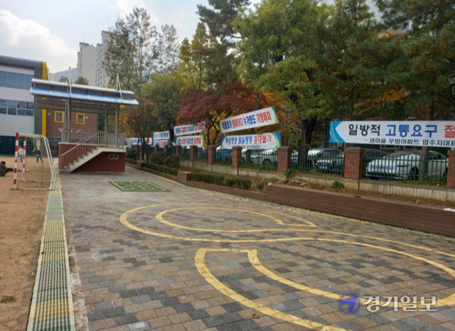 안양남초교 노후 건물 개선사업을 놓고 학교와 인근 주민들이 이견을 보이고 있다. 안양남초교 운동장 맞은 편에 A아파트 주민들이 붙인 현수막이 걸려 있다. 노성우기자