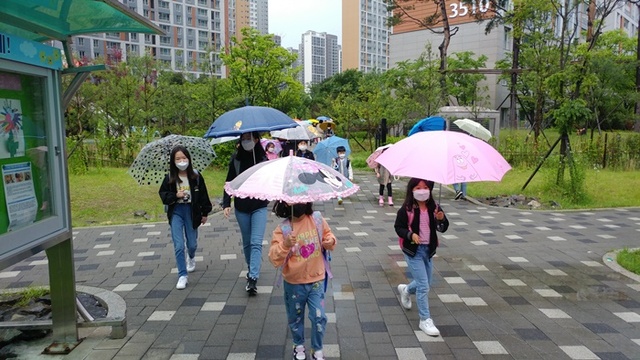 다산가람초 학생의 안전한 통학을 위해 단지내 인도를 통학로로 개방한 아파트 주민들. 샂진은 학생들이 등교하는 모습.