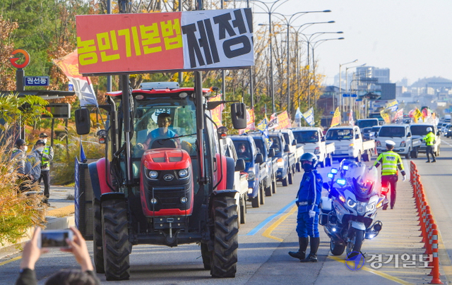 17일 서울에서 열리는 '농민총궐기대회'를 하루 앞두고 ‘농민 총궐기 성사를 위한 트랙터 대행진단’이 16일 오후 수원시 권선구 마중공원 인근 도로에서 농민기본법 제정, 식량주권 실현, 투기 농지 몰수 및 농지공영화, 식량자급률 법제화, 기후위기 대응, 농업재해보상법 제정 등을 요구하며 행진을 하고 있다.조주현기자