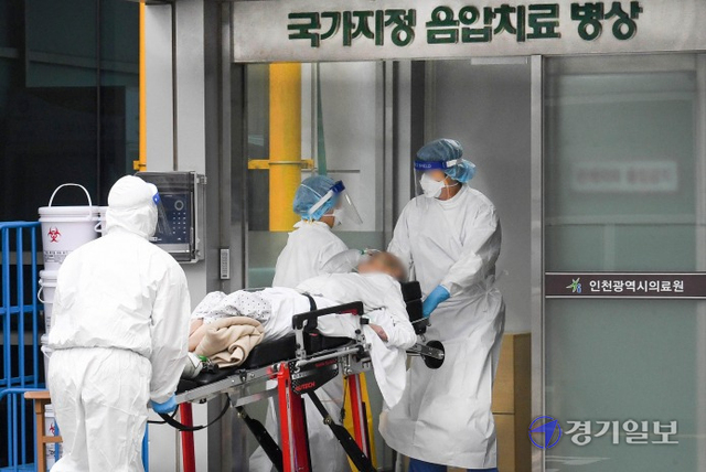 21일 오전 인천 동구 인천의료원 국가지정 음압치료 병동 앞에서 경기도에서 이송해온 코로나19 환자가 옮겨지고 있다. 수도권에서 코로나19 신규 확진자가 속출하면서 이날 병상 배정을 하루 넘게 기다리는 대기자 수가 800명을 넘어섰다. 장용준기자
