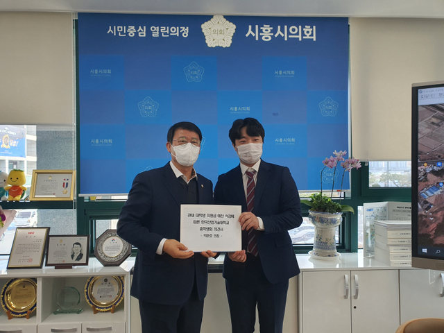 산기대  학생들이 시흥시의회에 대학생지원금 예산 삭감에 반대하는 의견서를 전달하고 있다.