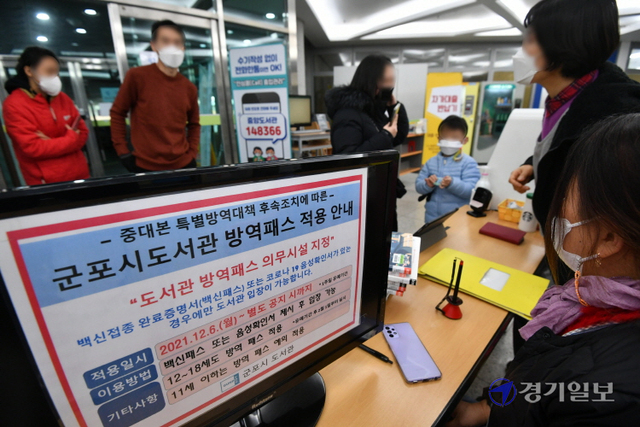 코로나19 특별방역대책이 시행된 6일 방역패스 의무화 안내문이 부착된 군포시도서관 출입구에서 직원들이 출입자를 안내하고 있다. 김시범기자