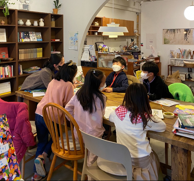 책방에 온 아이들 손님에게 그림책을 읽어주는 모습.