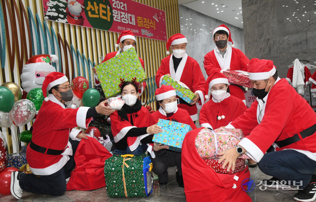 성탄절을 이틀 앞둔 23일 오후 김포아이사랑센터에서 열린 ‘2021 산타원정대 출정식’에서 산타 복장의 자원봉사자들이 지역 소외계층 아동 400명에게 전달할 선물 보따리를 꾸리고 있다. 조주현기자