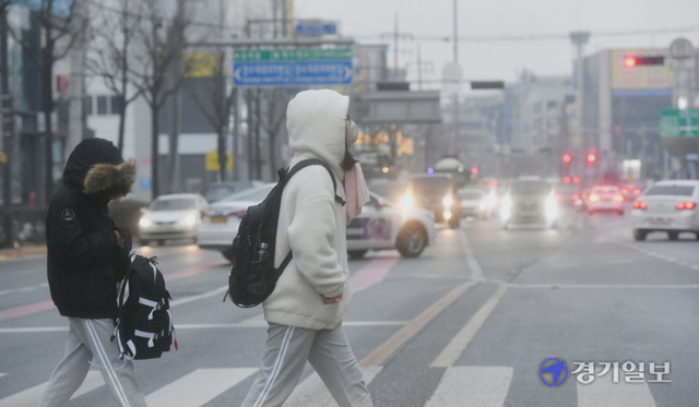 추위가 물러가자 초미세먼지가 몰려온 29일 오전 뿌옇게 흐려보이는 수원시내 한 횡단보도에서 시민들이 걸음을 재촉하고 있다. 김시범기자