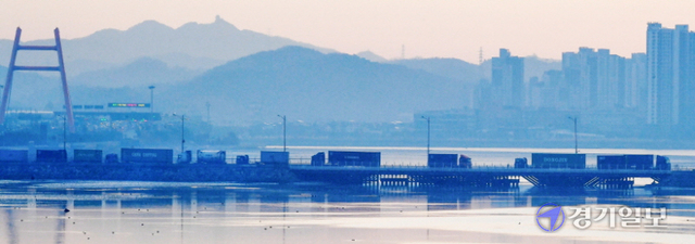 4일 오전 인천신항에서 화물을 싣은 컨테이너 차량들이 수도권 지역으로 통하는 제3경인고속도로 고잔톨게이트로 빠져 나가기 위해 인천 연수구 신항만교를 줄지어 건너고 있다. 인천신항(연수구 송도동)은 코로나19 여파 속에서도 컨테이너 처리물동량이 지난해 보다 5.7% 증가하며 수도권 관문항으로서의 지위를 확고히 하고 있다. 장용준기자