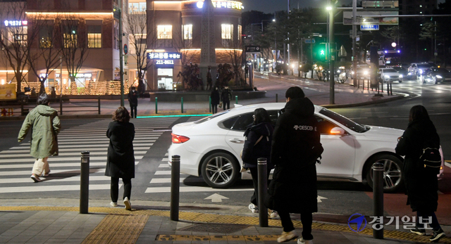지난 1일부터 횡단보도 우회전 시 '우선 멈춤' 등 보행자 보호 의무를 위반하면 과태료 부과 외에 운전자 보험료할증이 적용됨에도 아직 횡단보도에서 과속·신호무시하는 운전자들이 있어 주의가 요구된다. 6일 오후 수원시 광교중앙로 사거리에서 한 차량이 보행자를 무시하고 우회전하고 있다. 윤원규기자