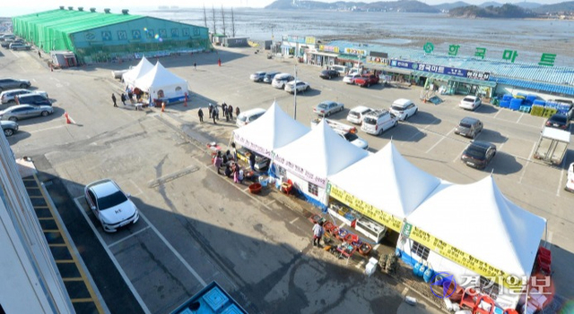 지난 6일 오전 영흥 수산물직판장 상인들이 불이 난 건물 옆 주차장의 임시 천막에서 장사를 하고 있다. 장용준기자