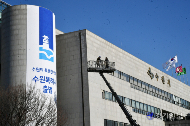 12일 오후 특례시 출범을 하루 앞둔 수원시청 외벽에 축하 현수막이 설치되고 있다. 김시범기자<br>