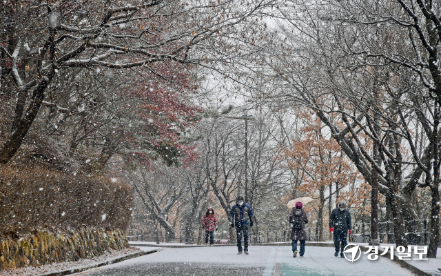 경기도 곳곳에 눈이 내린 17일 오후 수원 화성 둘레길에서 시민들이 산책을 하고 있다. 윤원규기자