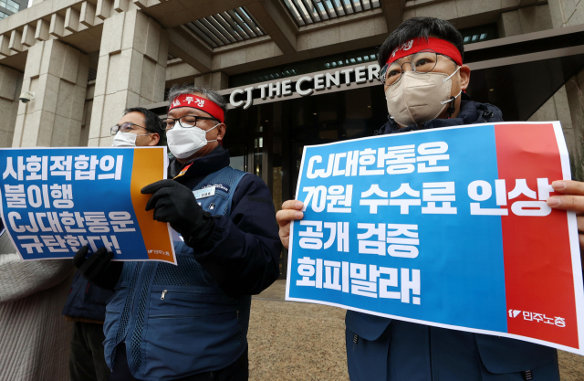 25일 오전 서울 중구 CJ그룹 본사 앞에서 열린 민주노총 전국동시다발 기자회견에서 택배노조 및 노동·시민단체 관계자들이 CJ대한통운의 사회적합의 이행을 촉구하는 손팻말을 들고 있다. 연합뉴스