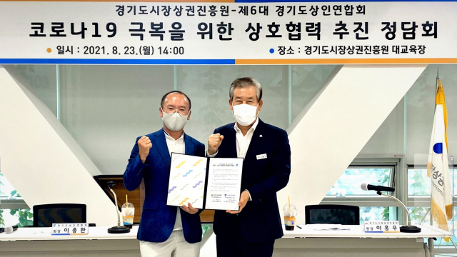 지난해 8월 열린 '코로나19 극복을 위한 상호협력 추진 정담회'에서 이홍우 경기도시장상권진흥원장과 이충환 경기도상인연합회장이 협력을 다짐하는 모습. 경기도시장상권진흥원 제공