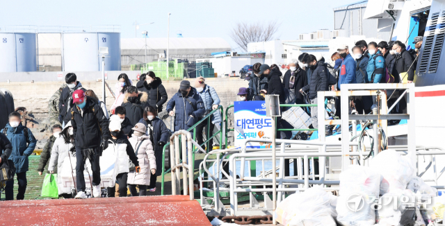 설 연휴 마지막날인 2일 오후 인천 옹진군 연평도에서 출발해 인천항연안여객터미널에 도착한 귀경객들이 고향의 선물을 들고 부두잔교를 빠져 나오고 있다. 장용준기자
