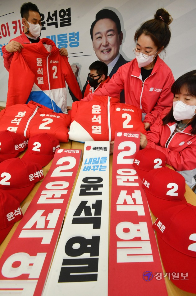 제20대 대통령선거 공식 선거운동 시작을 하루 앞둔 14일 더불어민주당 경기도당(왼쪽)과 국민의힘 경기도당에서 각각 관계자들이 이재명·윤석열 대선 후보 홍보물을 점검하고 있다. 김시범기자