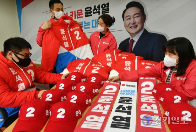 제20대 대통령선거 공식 선거운동 시작을 하루 앞둔 14일 더불어민주당 경기도당(왼쪽)과 국민의힘 경기도당에서 각각 관계자들이 이재명·윤석열 대선 후보 홍보물을 점검하고 있다. 김시범기자