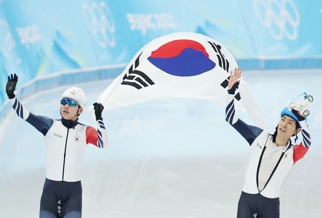 정재원(왼쪽)과 이승훈이 19일 중국 베이징 국립 스피드스케이팅 경기장에서 열린 2022 베이징 동계올림픽 스피드스케이팅 남자 매스스타트 결승에서 각각 은메달과 동메달을 획득한 뒤 함께 태극기를 들고 관중석을 향해 인사하고 있다. 연합뉴스