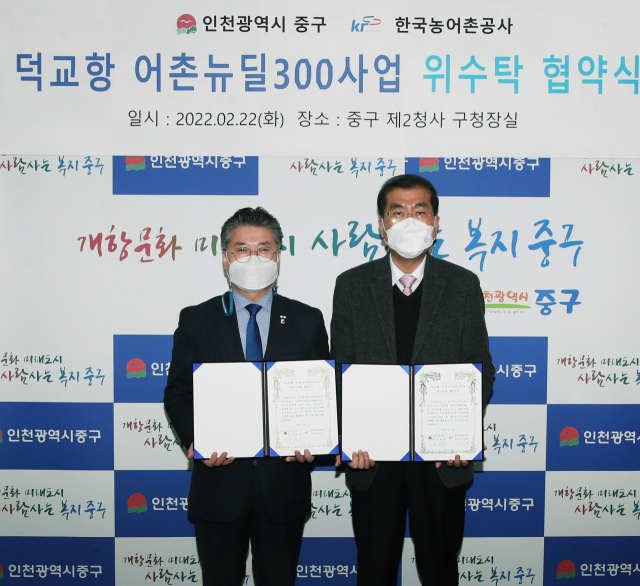 홍인성 인천 중구청장(왼쪽)이 22일 한국농어촌공사 김포지사와 '덕교항 어촌뉴딜300'사업 위·수탁 협약을 한 뒤 기념촬영을 하고 있다./중구 제공