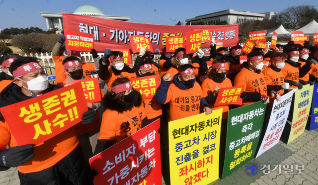 22일 오전 국회의사당 정문에서 경기도자동차매매사업조합 엄태권 조합장과 조합원 등 중고차 업계 관계자들이 중고차 판매업의 생계형 적합업종 지정을 촉구하는 집회를 열고 현대차·기아의 중고차 시장 진출을 규탄하는 구호를 외치고 있다.조주현기자
