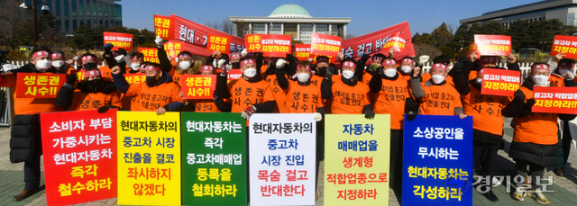 22일 오전 국회의사당 정문에서 경기도자동차매매사업조합 엄태권 조합장과 조합원 등 중고차 업계 관계자들이 중고차 판매업의 생계형 적합업종 지정을 촉구하는 집회를 열고 현대차·기아의 중고차 시장 진출을 규탄하는 구호를 외치고 있다.조주현기자