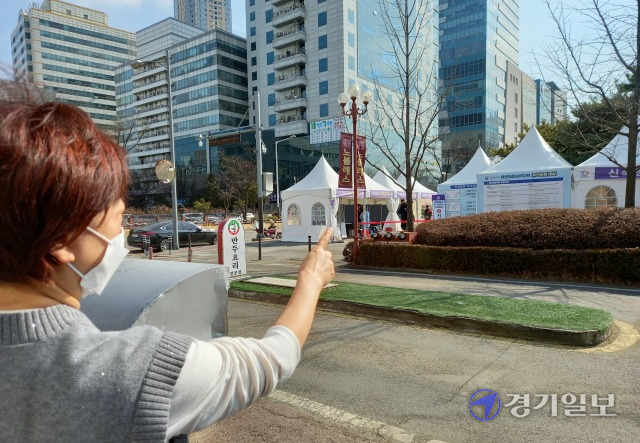 안양시 범계평화공원 앞 상가에 설치된 코로나19 신속항원 검사부스로 인해 상인들이 이중고를 호소하고 있다.한 상인이 가게 앞을 막아선 검사소를 가리키고 있다. 노성우기자