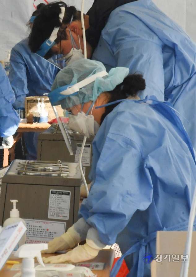수도권에 한파가 계속된 23일 오후 광명시 스피돔 코로나19 임시선별검사소에서 의료진 등 현장근로자들이 강추위 속에 난로에 몸을 녹이며 고군분투 하고 있다.조주현기자