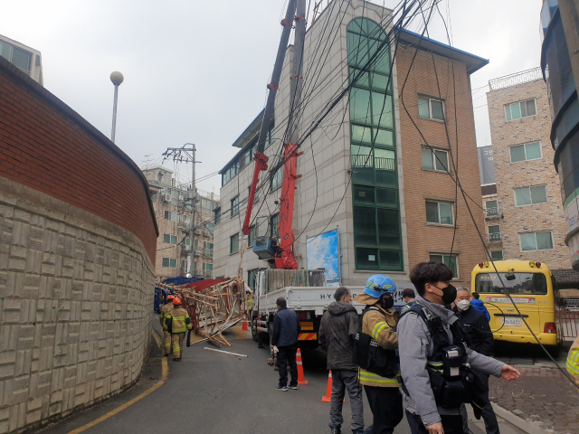 부러진 크레인 붐대와 떨어진 교회 종탑주변을 119대원들이 살피고 있다.(사진= 독자제공)