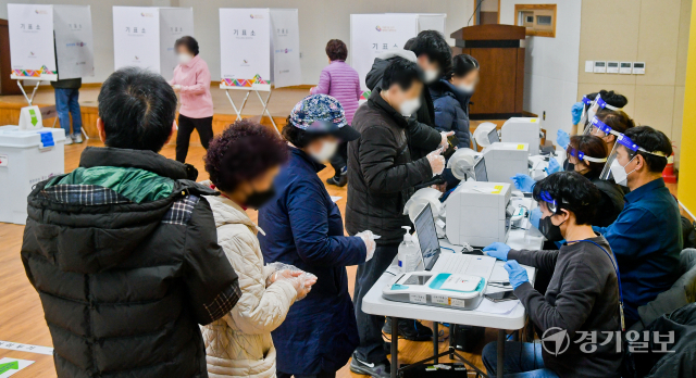 제20대 대통령선거 사전투표가 시작된 4일 오전 수원특례시 매탄4동 사전 투표소에서 유권자들이 투표용지를 받고 있다. 윤원규기자