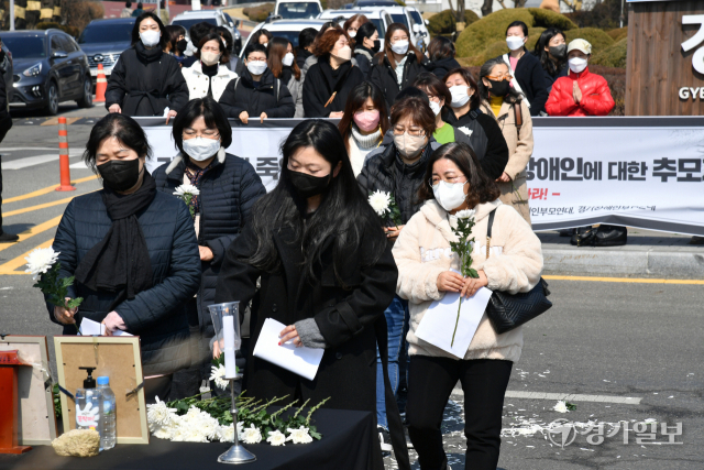 8일 오전 경기도청 앞에서 열린 ‘가족에게 죽임을 당한 두명의 발달장애인에 대한 추모제 ’에서 경기장애인부모연대 회원 등이 헌화 및 묵념을 하고 있다. 김시범기자
