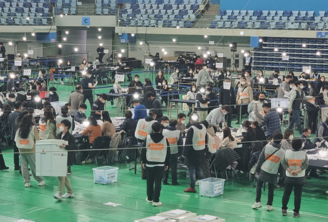 제20대 대통령 선거가 치러진 9일 오후 8시50분께 인천 남동구 남동체육관 개표장에서 국민의힘측 개표 참관인들이 사전투표 용지 색상이 다르다며 문제를 제기해 특정 개함부에서 개표가 일시 중단, 관계자들이 모여있다. 이지용 기자