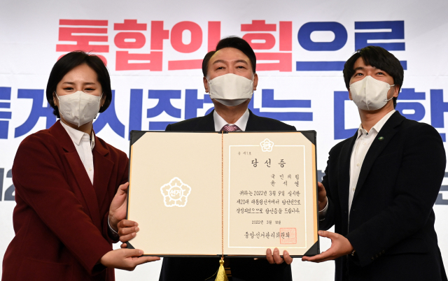 윤석열 대통령 당선인이 지난 10일 오후 국회 도서관에서 열린 국민의힘 선대본부 해단식에서 청년 보좌역들로부터 당선증을 전달받고 있다.국회사진기자단
